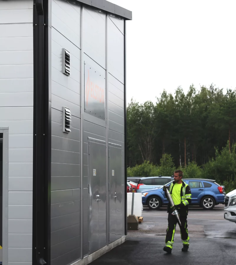 Elstor energy storage. Man carrying piece of a pipe.